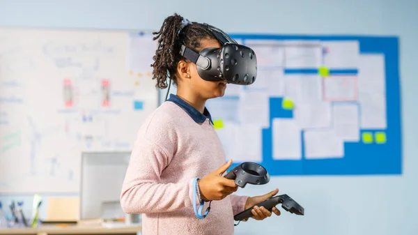 Általános iskola Computer Science Class: Aranyos lány visel kiterjesztett valóság headset és használata vezérlők tanulságok virtuális valóság Izgalmas, kíváncsi és érdekelt a tudás — Stock Fotó