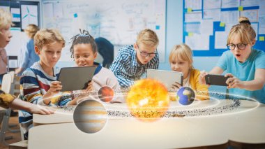 Fen Bilimi sınıfındaki Okul Çocukları Grubu Artırılmış Gerçeklik Yazılımı ile Dijital Tablet Bilgisayarları Kullan, Güneş Sistemi 'nin Eğitimsel 3D Animasyonuna Bakıyor. VFX, Özel Efektler Hazırlama