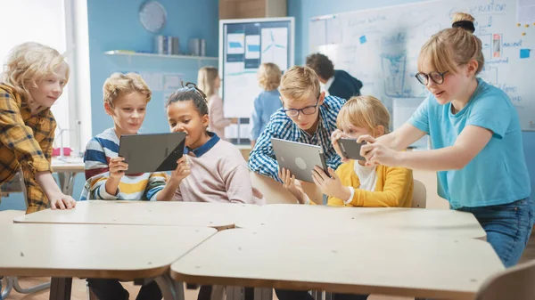 Scuola elementare Computer Science Class: I bambini utilizzano computer tablet digitali e smartphone con software di realtà aumentata, Sono ri eccitato, pieno di meraviglia. Bambini in STEM, Giocare e Imparare — Foto Stock