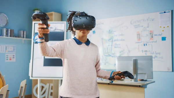 Clase primaria de ciencias de la computación: Linda chica con auriculares de realidad aumentada y el uso de controladores aprende lecciones de realidad virtual Emocionado, curioso e interesado en el conocimiento —  Fotos de Stock