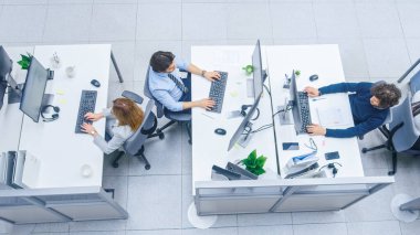 Masaüstü Bilgisayarları, Konuşan, Müşteri Desteğini Yapan, Müşterilerle İletişim, İstatistikleri İzleyen Farklı Profesyonellerin Parlak Ofis Sıralarında. Yüksek Açı Atışı