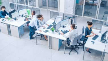 Masaüstü Bilgisayarları, Müşteri Desteği Yapan, Müşterilerle İletişim kuran, İstatistikleri İzleyen, Yürüyen Thorugh Koridoru 'nda çalışan Genç Profesyonellerin Parlak Ofis Sıralarında. Yüksek Açı Atışı