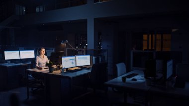Ofiste Gece Geç Saatlere Kadar Çalışmak: İş kadını Masaüstü Bilgisayarı Kullanıyor, Analiz Ediyor, Belgeleri Kullanıyor, Sorunları Çözüyor, Önemli Projeyi Bitiyor. Çalışkan Hırslı Genç İşçi