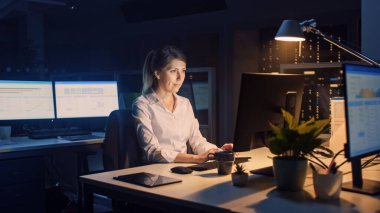 Ofiste Geç Saatlere Kadar Çalışmak: İşkadını Masaüstü Bilgisayarı Kullanıyor, Analiz Ediyor, Belgeleri Kullanıyor, Sorunları Çözüyor, Projeyi Bitiyor