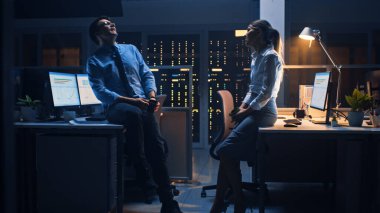 Gece geç saatlerde şirket ofisinde iki genç profesyonel arkadaşça sohbet ediyor, haberleri paylaşıyor, iş hakkında konuşuyor, flört ediyor.