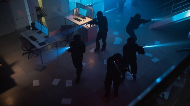Maskeli Özel Tim, Silahlı SWAT Polisleri Masa ve Bilgisayarlı Karanlık Ele Geçirilmiş Ofis Binası 'na saldırdı. Tüfekleri ve fenerleri olan askerler ilerleyin ve etrafını sarın. Üst- görünüm Kamerası.