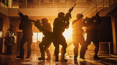 Silahlı SWAT 'tan Maskeli İtfaiye Ekibi Masa ve Bilgisayarlı Güneşli Ofis Binası' na baskın düzenledi. Tüfekli askerler ilerleyin ve etraflarını sarın. Sarı Sıcaklık Filtresiyle Çekilmiş.