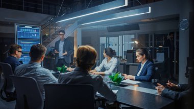 Kurumsal Toplantı Odasında: Enerji ve Kendinden emin Genç Girişim Yaratıcısı Yöneticiler Kurulu Yatırımcılarına Etkili Konuşma Sunumu ve Sunumu için Dijital Etkileşimli Whiteboard Kullanıyor
