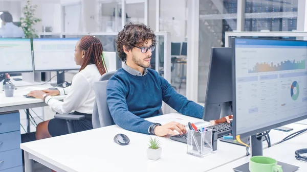 No escritório corporativo ocupado grande trabalhador profissional usando o computador desktop, em torno dele empresários e especialistas que trabalham com clientes, tendo discussões e estatísticas de análise — Fotografia de Stock