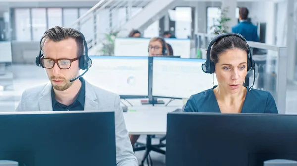 En la Oficina de Espacio Abierto Moderno: Equipo de Atención al Cliente Personal y Vendedores Trabajando en sus Computadoras de Escritorio, Usando Auriculares y Llamadas, Hablando con Clientes —  Fotos de Stock