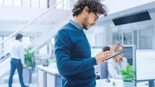 No escritório moderno brilhante: O trabalhador bonito do escritório está de pé e usando o computador digital do tablet. Jovens Empresários Planejando e Resolvendo Problema. — Fotografia de Stock