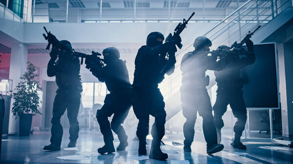 Masked Fireteam of Armed SWAT Police Officers Storm a Bright Seized Office Building with Desks and Computers. Soldiers with Rifles Move Forwards and Cover Surroundings.