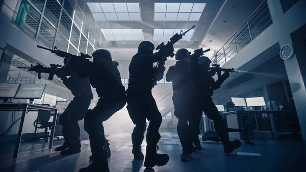 Masked Team of Armed SWAT Police Officers Move in a Hall of a Dark Seized Office Building with Desks and Computers. Soldiers with Rifles and Flashlights Surveil and Cover Surroundings. — Stock Photo, Image