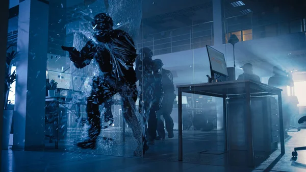 Masked Squad of Armed SWAT Police Officers Storm a Dark Seized Office Building with Desks and Computers. Soldier Breaks a Glass with His Arm and Team Continue to Move and Cover Surroundings. — Stock Photo, Image