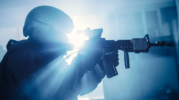 Närbild Porträtt av Masked Squad Medlem av väpnade SWAT poliser som stormar en mörk beslagtagen kontorsbyggnad med skrivbord och datorer. Soldater med gevär och ficklampor. — Stockfoto