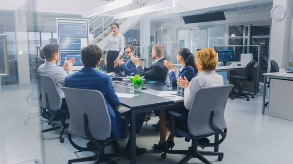 Dans la salle de réunion de l'entreprise : Les femmes exécutives utilisent le tableau blanc interactif numérique pour la présentation à un conseil d'administration, avocats, investisseurs. Tout le monde applaudit. L'écran montre les données de croissance de l'entreprise — Photo