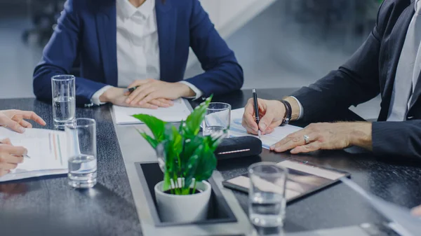 Dans la salle de réunion de l'entreprise Gros plan sur les mains de l'homme d'affaires Signature du contrat. Personnes assises à la table de conférence — Photo