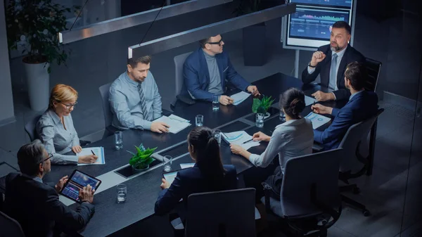 Dans la salle de réunion d'entreprise : Groupe diversifié d'associés et de cadres d'affairesParler, négocier, débattre, travailler avec des documents, stratégie de planification. Tard dans la nuit au bureau. Angle élevé — Photo