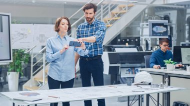 Endüstriyel Mühendislik Tesisinde: Baş Mühendis ile Kadın Tasarımcı, Motor Tasarım Teknik Tasarımlarını 3 boyutlu olarak manipüle etmek için Gelişmiş Gerçeklik Uygulaması Kullanıyor. Yüksek Teknoloji Ofisi. Model