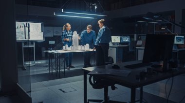 Yaratıcı Mimarlık Ajansı 'nda İki Profesyonel Tasarımcı Şef Proje Mühendisi ile Şehir Bölgesi Modeli Üzerinde Çalışıyor. Şehir Planlayıcıları İşlevsel İnşaat Modeli Üzerinde Çalışıyor.