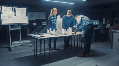 Yaratıcı Mimarlık Ajansı 'nda İki Profesyonel Tasarımcı Şef Proje Mühendisi ile Şehir Bölgesi Modeli Üzerinde Çalışıyor. Şehir Planlayıcıları İşlevsel İnşaat Modeli Üzerinde Çalışıyor.