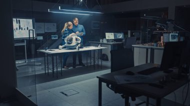 Gece geç saatlerde Robot Mühendisliği Tesisi İki Teknik Mühendisler Tekerlekli Robot Prototipi hakkında konuşur ve çalışır. Arka plan Yüksek Teknoloji Araştırma Merkezi Ekran Gösterme Teknolojisi Tasarımı