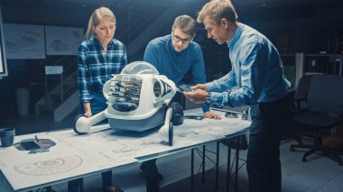 Robot Mühendislik Tesisi Üç Teknik Mühendisler Tekerlekli Robot Prototipi hakkında konuşuyor ve çalışıyor. Ekran Endüstriyel Tasarımı Gösteren Arkaplan Yüksek Teknoloji Araştırma Merkezi 'nde. Kara Vuruş