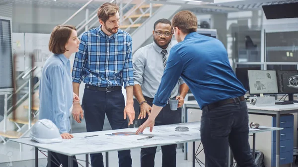 Nello Studio di Ingegneria Industriale: Designer Femminile Lavora con Ingegnere Industriale e Master Technician, Hanno Discussione, Analizzare Progettazione Motore Bozze Tecniche che sono sdraiati sul tavolo — Foto Stock