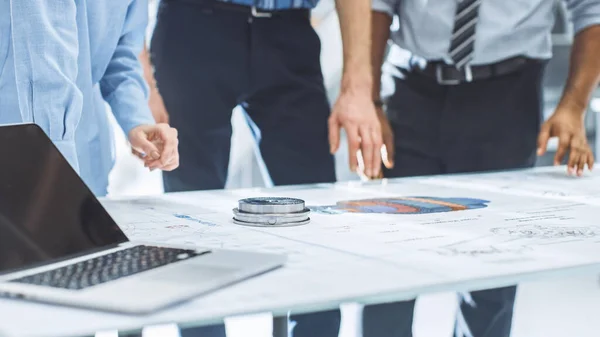 Installation de génie industriel : Gros plan sur les mains d'un groupe d'ingénieurs, de techniciens et de spécialistes lors d'une réunion, traçant les lignes et analysant les ébauches techniques de conception des moteurs posées sur la table — Photo