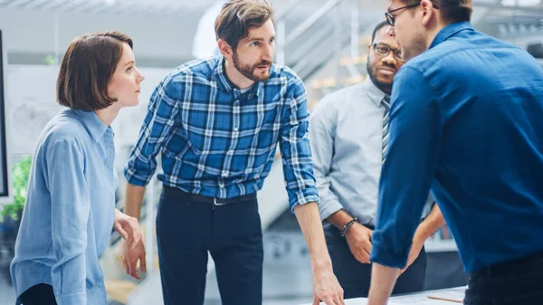 Na Instalação de Engenharia Industrial: Grupo Diverso de Engenheiros e Técnicos em uma Reunião Reúna-se em torno da Mesa Desvendar Folhas de Desenho de Motor Rascunhos Técnicos, Ter Discussão, Analisar Desenhos — Fotografia de Stock