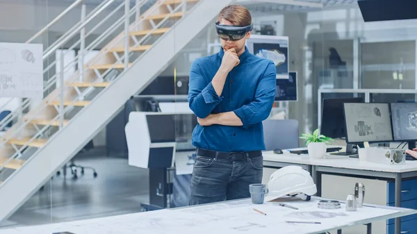 Développeur de logiciels d'ingénierie Porter un casque de réalité virtuelle utilise des gestes pour interagir avec la réalité augmentée tout en concevant un modèle de moteur industriel dans une installation moderne. Concept de maquillage AR — Photo