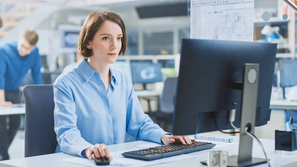 2012 년 7 월 1 일에 확인 함 . 《 In the Industrial Engineering Facility: Portrait of the Smart and Beautiful Female Engineer Working on Desktop Computer 》. 배경 전문가들과예 술자들이 드래프트와 드래프트로 작업하는 모습 — 스톡 사진