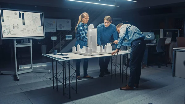 En la Agencia Arquitectónica Creativa Dos Diseñadores Profesionales Hablan con el Ingeniero Jefe de Proyectos, Trabajan en un Modelo de Distrito de la Ciudad. Planificadores urbanos trabajan en un modelo de construcción funcional. — Foto de Stock