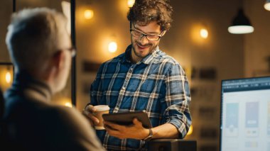 Akşamları Yaratıcı Ortaçağ Mobil Yazılım Tasarımcısı Akıllı Telefon Uygulama Tasarımı ile Masaüstü Bilgisayarı Kullanır, Tablet Bilgisayar kullanan Genç Uzmanla Sohbeti Var.