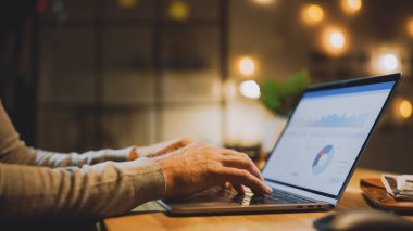 Erkek Uzmanların Elleri Üzerine Yakın Çekim Dizüstü Bilgisayar, Ekran Çeşitli Veri ve İstatistikleri Gösteriyor. Stylish Stüdyo Ofisinde Arka planda Akşam