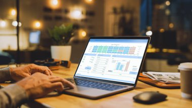 Erkek Uzmanların Elleri Üzerine Yakın Çekim Dizüstü Bilgisayar, Ekran Çeşitli Veri ve İstatistikleri Gösteriyor. Stylish Stüdyo Ofisinde Arka planda Akşam