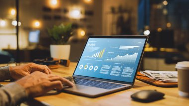 Erkek Uzmanların Elleri Üzerine Yakın Çekim Dizüstü Bilgisayar, Ekran Çeşitli Veri ve İstatistikleri Gösteriyor. Stylish Stüdyo Ofisinde Arka planda Akşam