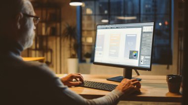 Yeni Cep Telefonu Uygulama Uygulaması Tasarımı, Yazılım UI Geliştirme Omuzlu Orta Çağ Uygulama Geliştiricisi Masaüstü Bilgisayarını kullanarak. Şehir Penceresi Görünümü ile Ofiste Akşam