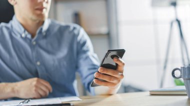 Girişimci Masasında Stil Ofisinde Belgelerle Çalışıyor, Akıllı Telefon Kullanıyor, Sosyal Medya Uygulamasını Kullanıyor, İş ortaklarını E- postalıyor, Mesajlaşıyor.