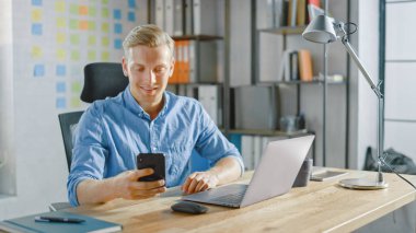 Moda Ofisi 'nde Masasında Oturan Yaratıcı Girişimci, Smartphone, Sosyal Medya Uygulamaları, E- posta Ortakları, Mesajlaşma Arkadaşları Kullanıyor ve Kullanıyor