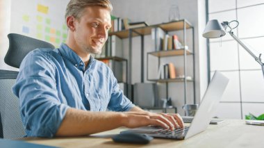 Ofisteki masasında oturan yakışıklı sarışın iş adamı dizüstü bilgisayarda çalışıyor. Yazılım Unicorn Startup Project üzerinde çalışan yaratıcı girişimci. Üniversite için Öğrenci Yazma Kağıdı