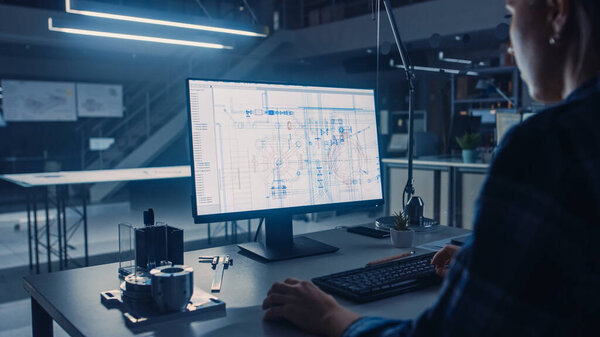 Инженеры работают на настольных компьютерах, экранируют САПР с технологическим Blueprints. Инженерный комплекс промышленного дизайна. Над плечом