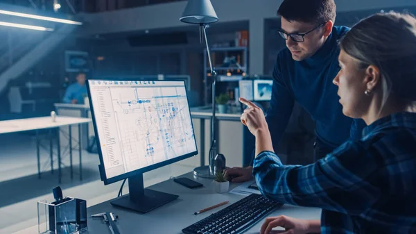 Ingenieurin, die an Desktop-Computern arbeitet und CAD-Software mit technischen Entwürfen zeigt, erklärt ihre männliche Projektmanagerin die Besonderheiten ihres Berufs. Industrial Design Engineering Facility Office — Stockfoto