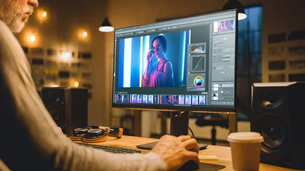 Creative Middle Aged Digital Editor werkt in Picture Editing Software op zijn personal computer met groot display. Stijlvol modern studio kantoor in de avond. — Stockfoto