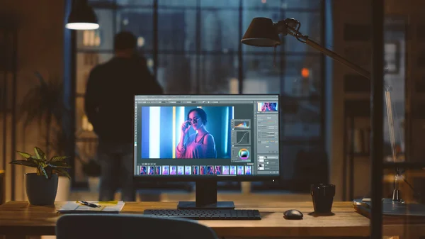 Desktop Computer met Photo Editing Software staan op het bureau in het moderne creatieve kantoor. In de achtergrond Designer Drinks from a Cup kijkt naar de Night City uit het raam. — Stockfoto