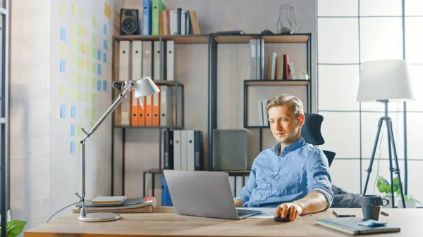 Creative Entrepreneur Sitting at His Desk Works on a Laptop in the Stylish Office, Χρησιμοποιεί το Σημειωματάριο για τα Social Media Apps, Emailing Business Associates, Reading News, Περιήγηση στο Διαδίκτυο — Φωτογραφία Αρχείου