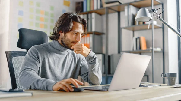 Bonito homem de negócios hispânico de cabelos compridos sentado em sua mesa no escritório funciona em um laptop. Desenvolvimento Criativo Novo Projeto de Startup de Unicorn de Software, Finalizando a Transação de Negócios — Fotografia de Stock