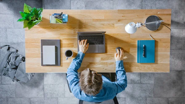 Top View Shot: Empresário sentado na mesa de madeira funciona em um laptop em seu Home Office. Ele Tipos, Escreve e-mails, Surfa na Internet, Designs Software, Compras Online — Fotografia de Stock