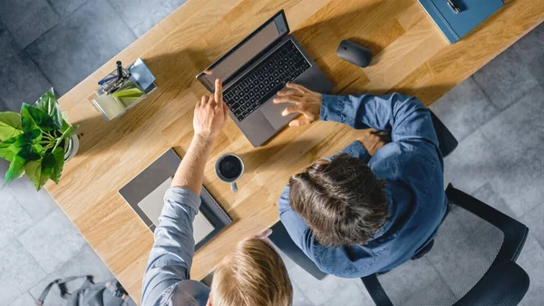 Dizüstü bilgisayarında çalışan, menajeriyle konuşan ve proje konseptiyle ilgili bir tavsiyeyi dinleyen genç bir iş adamının en iyi görüntüsü. İki Adam İş Tartışıyor