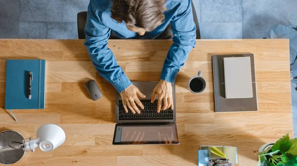 Top View Shot: W biurze Biznesmen siedzi w drewnianym biurku Pracuje na laptopie w swoim biurze. Pisze na maszynie, pisze maile, surfuje po Internecie, projektuje oprogramowanie — Zdjęcie stockowe